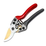 Goldoma pruning shears cutting a thick tree branch, with wood chips flying.