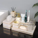 Gold toothbrush holder with marble base, close-up view.