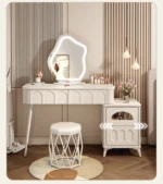 Modern wood makeup vanity table with mirror, drawer, and stool in a bedroom setting