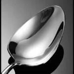 Elegant French stainless steel cutlery set with pointed tail handles on a wooden table