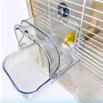 White bird bath tub shaped like a cage, mounted on a fence in a sunny garden.