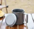 Double wall titanium mug with lid and tea strainer on a wooden table