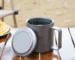 Double wall titanium mug with lid and tea strainer on a wooden table