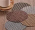 Round woven heat resistant placemats on a dining table with hot coffee mugs