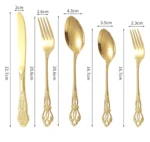 Gold flatware set with spoon, fork, and steak knife on a white tablecloth