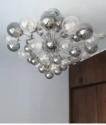 Smoky gray chandelier with glass bubbles hanging over a modern dining table
