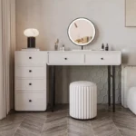 Modern minimalist makeup vanity table with mirror and stool in a bedroom setting