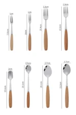 Stainless steel flatware set with wooden handles displayed on a table