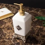 Angle view of the toothbrush holder with two toothbrushes inside, highlighting its ceramic texture and gold gloss.