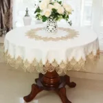Elegant lace tablecloth with rose gold embroidery on a dining table