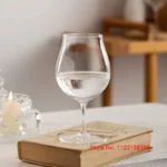 Kimura Shouko ultra thin wine glass on a wooden table, catching light