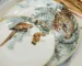 Hand painted ceramic plates with jungle motif on a rustic wooden table