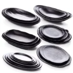 Black melamine dinner plates stacked elegantly on a wooden table