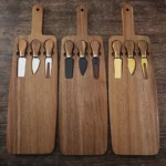 Acacia cheese board set with cheese knives and wooden cutting board on a table