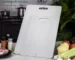 Ultra thin titanium cutting board on a kitchen counter with fresh vegetables and a knife