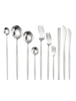Elegant stainless steel flatware set with forks, spoons, and knives arranged on a wooden table