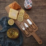 Acacia cheese board set with cheese knives and wooden cutting board on a table
