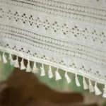 Retro polka dot tablecloth with fringe on a wooden table