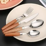 4-piece stainless steel flatware set with sapele wooden handles on a table