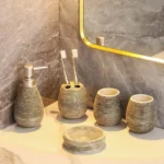 Vintage handmade ceramic five-piece bathroom set on a wooden countertop, warm natural light.