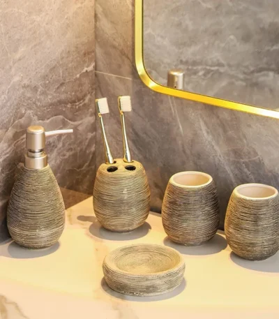 Vintage handmade ceramic five-piece bathroom set on a wooden countertop, warm natural light.