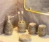 Vintage handmade ceramic five-piece bathroom set on a wooden countertop, warm natural light.