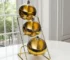 Set of stainless steel dipping bowls with golden rim on a wooden table
