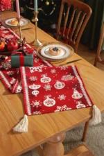 Red and green Christmas table runner with plaid pattern on dining table