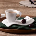 White porcelain espresso cup with wavy design on saucer, modern home decor