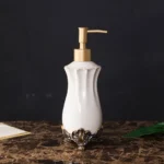Set of white porcelain bathroom accessories including a toothbrush holder and lotion bottle.