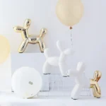Gold dog statue on a white desk with a pen holder and notebook.
