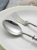 Gold flatware set with Roman handle luxury cutlery on a wooden table