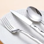 Luxury stainless steel flatware set with diamond 3D texture on a wooden table