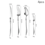 Elegant French stainless steel cutlery set with pointed tail handles on a wooden table