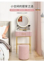 Marble top dressing table with lighted mirror and stool in a bedroom setting