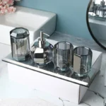 Glass soap dispenser set with silver pump, placed on marble surface.
