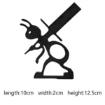 Side view showing the ant's legs gripping the toilet paper roll, against a tiled bathroom wall.