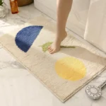 Modern abstract art non slip bathroom rug with vibrant colors and textured surface on a bathroom floor