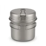 Titanium camping cookware set with folding handles, pot and pan on a campfire