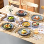 Grey-blue reactive glaze stoneware dinnerware set with plates and bowls on wooden table