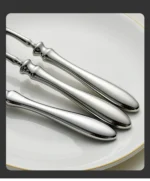 Gold flatware set with Roman handle luxury cutlery on a wooden table