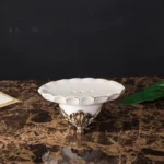 Rinsing cup with a scalloped rim and gold detailing, photographed from above.