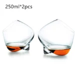 Rotating whiskey glass on a wooden table with amber liquid swirling inside