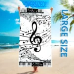 Vibrant guitar beach towel with colorful musical notes pattern on a sandy beach