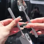 Two stainless steel ice cream spoons with ergonomic handles, one scooping a bowl of vanilla ice cream