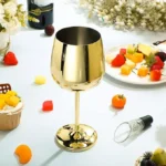 Set of 6 stainless steel wine glasses on a wooden table with red wine