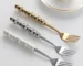 Stainless steel flatware set with ceramic pearl handles on wooden table
