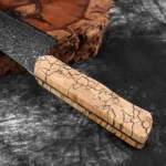 Damascus steel chef knife with woven wood handle on cutting board