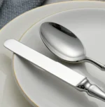 Gold flatware set with Roman handle luxury cutlery on a wooden table