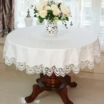 Elegant lace tablecloth with rose gold embroidery on a dining table